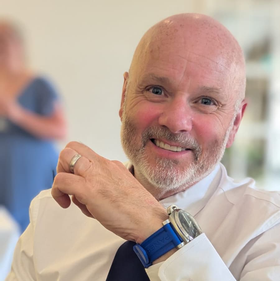 Bald man smiling with blue watch